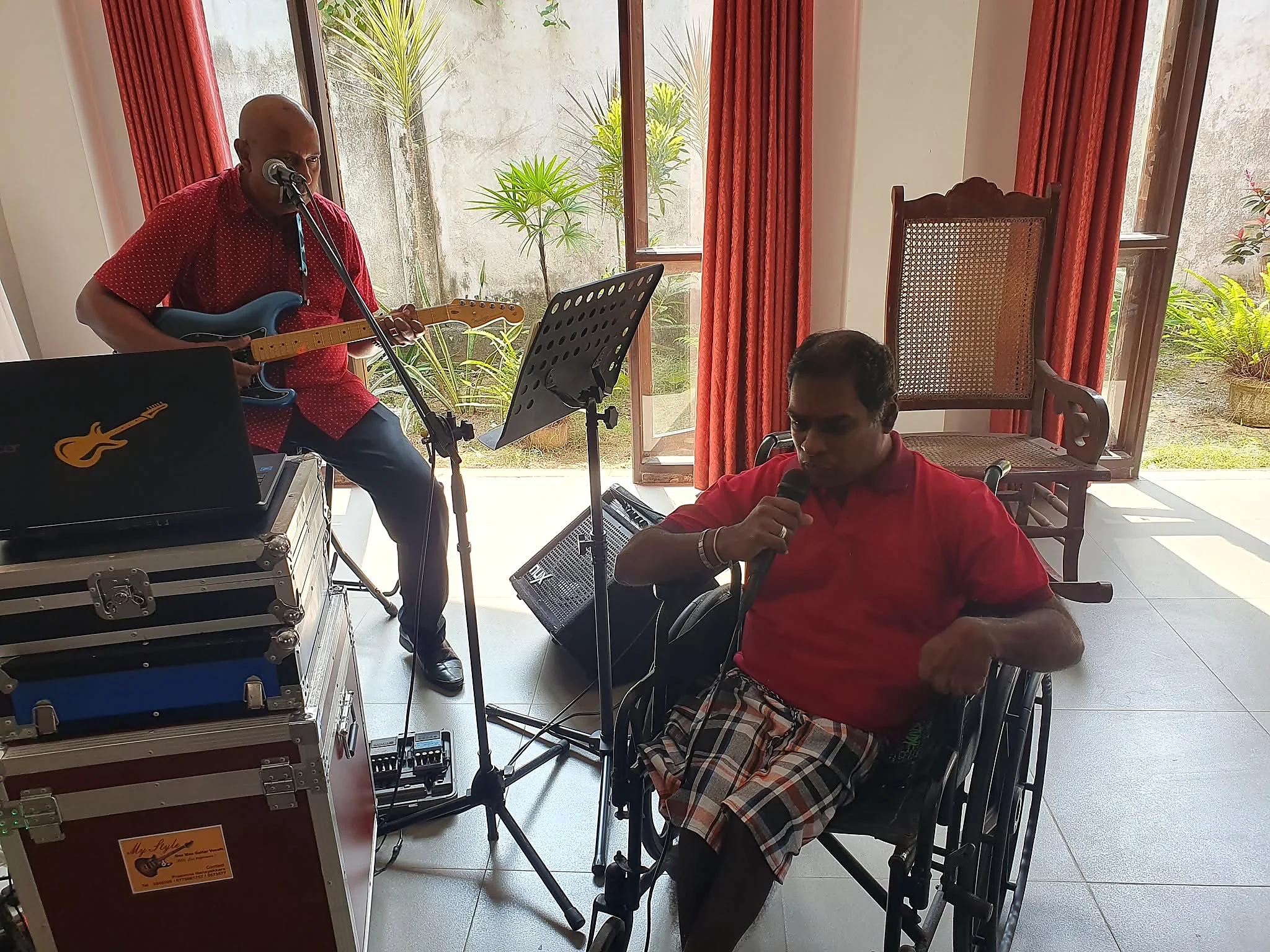 A resident singing while a musician plays guitar at the Home